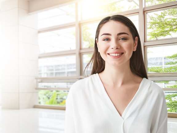 Eine lachende Frau steht vor einem Fenster , Titelbild Eine lachende Frau vor einem Fenster.