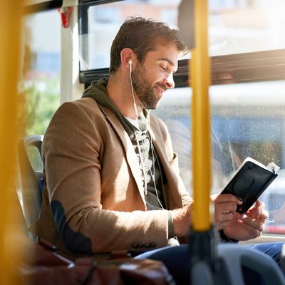 Ein Mann sitzt im Bus und liest ein Buch. Ein Mann sitzt im Bus und liest ein Buch.