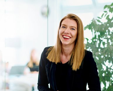 Eine sympathische junge Frau, die mit einem Lächeln in die Kamera blickt