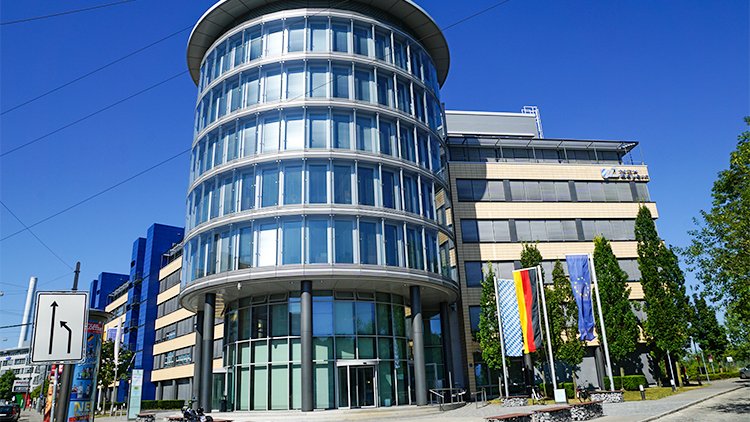 © Bayerischen Staatsministerium für Gesundheit, Pflege und Prävention Ein rundes Gebäude mit einer großen Glasfensterfront.